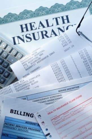 Insurance paperwork and billing documents laid out on a desk